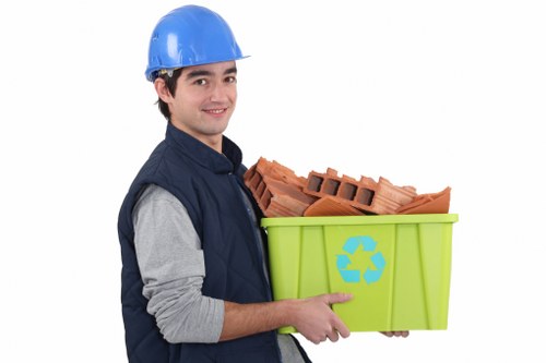 Worker wearing PPE preparing containers for commercial waste pickup