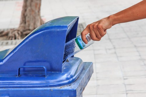 Worker carrying furniture down stairs for commercial waste removal